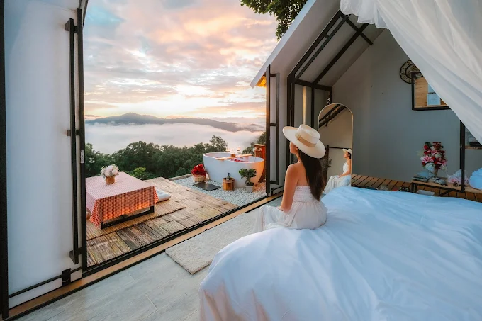 The retractable roof of the cabin is open, revealing the starry night sky from the bed.