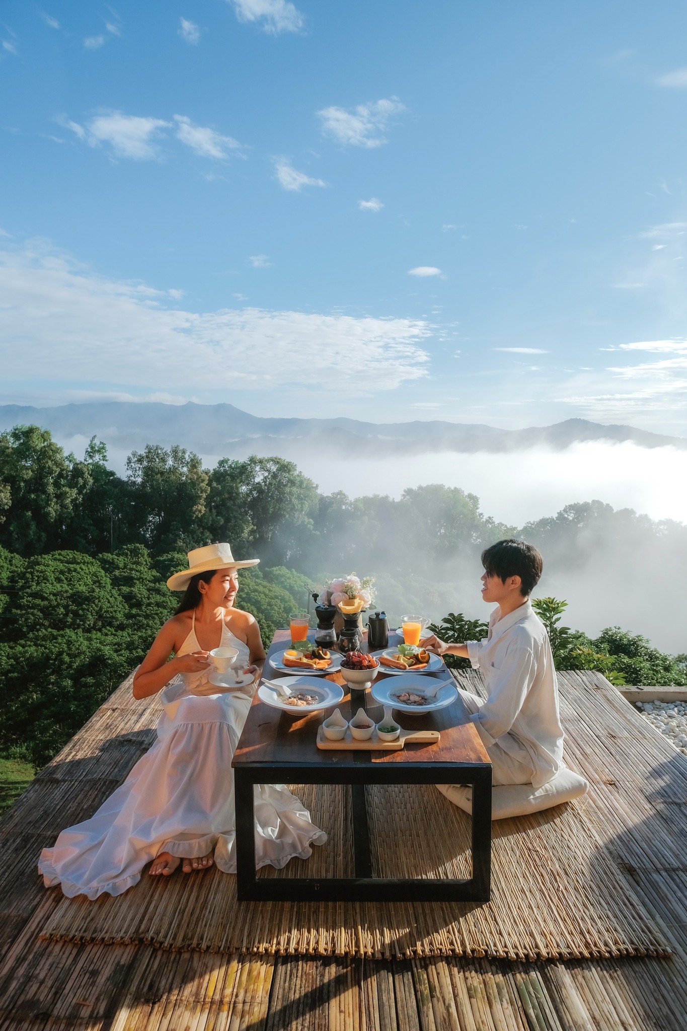 View from the cabin's deck, showing a panoramic vista of mountains with a sea of clouds in the valley below at sunrise.